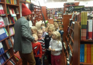 Dzieci z zaciekawieniem przyglądają się mężczyźnie w czapce krasnala.